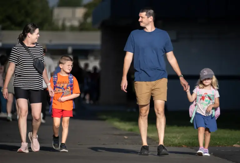 Victoria and Zac Applegate walk their son Ollie, 7, to...