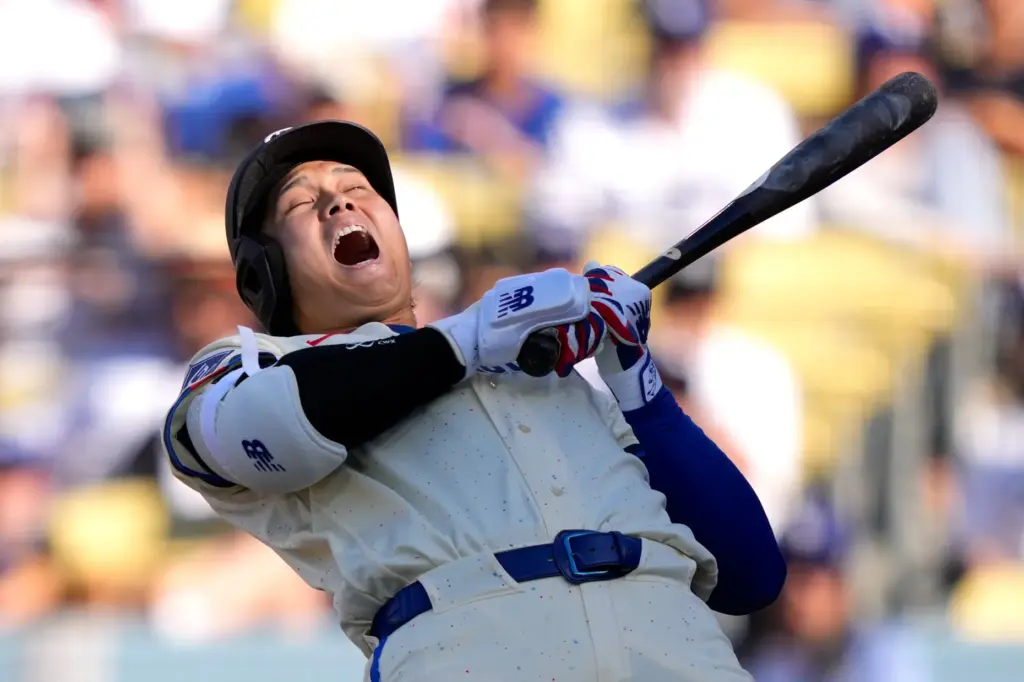Dodgers’ Shohei Ohtani ducks out of the way of a...