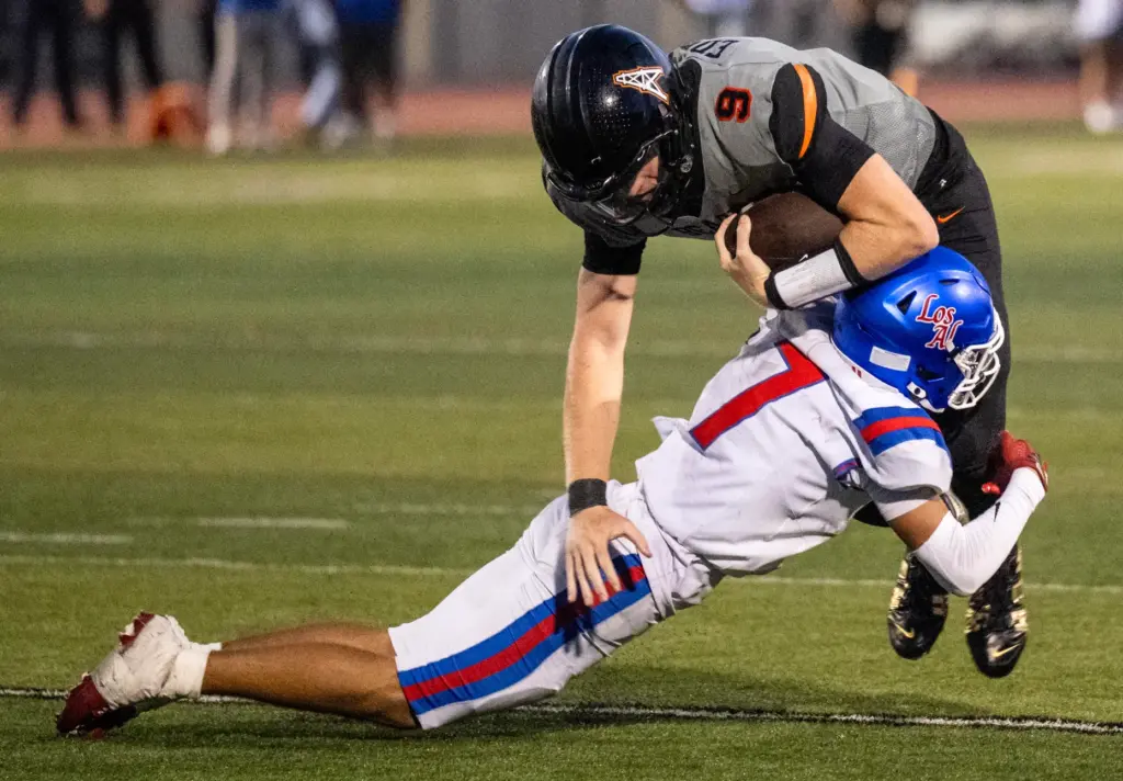 Los Alamitos defensive back Corbin Rogers (7) tackles Huntington Beach...
