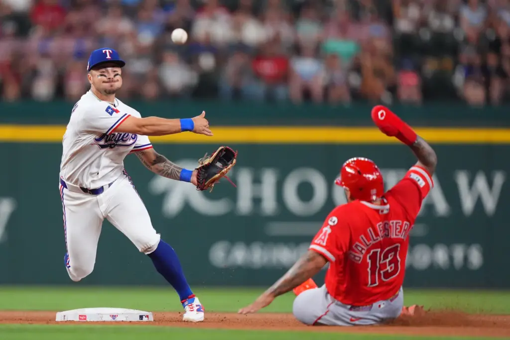 Texas Rangers second baseman Cody Freeman, left, throws to first...