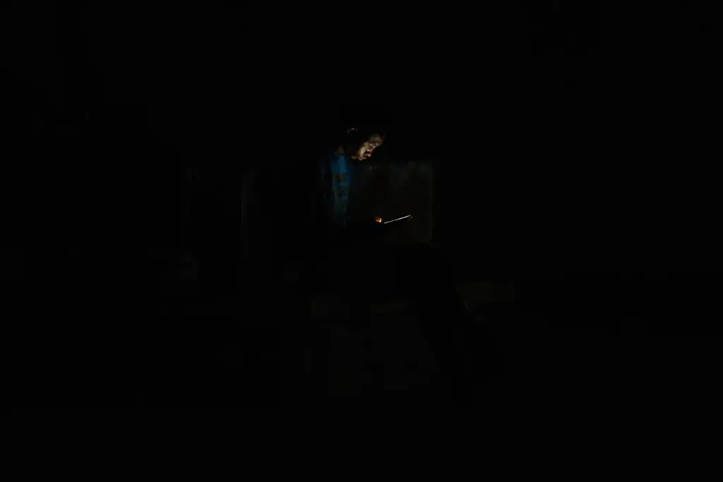 A man looks at his cell phone during a blackout...