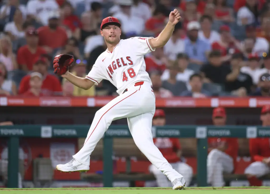 Angels starting pitcher Reid Detmers reacts to his late throw...
