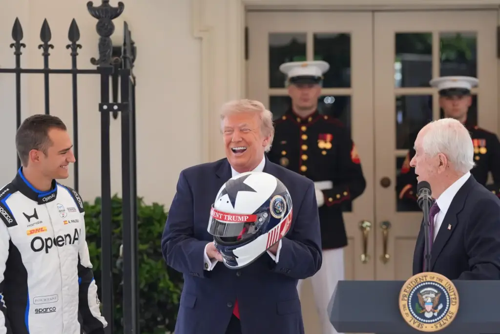 President Donald Trump reacts after receiving a helmet.