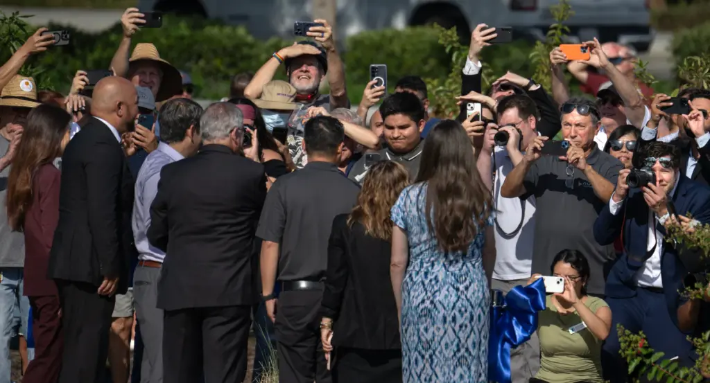 Photographers focus on officials during a ribbon-cutting ceremony celebrating the...
