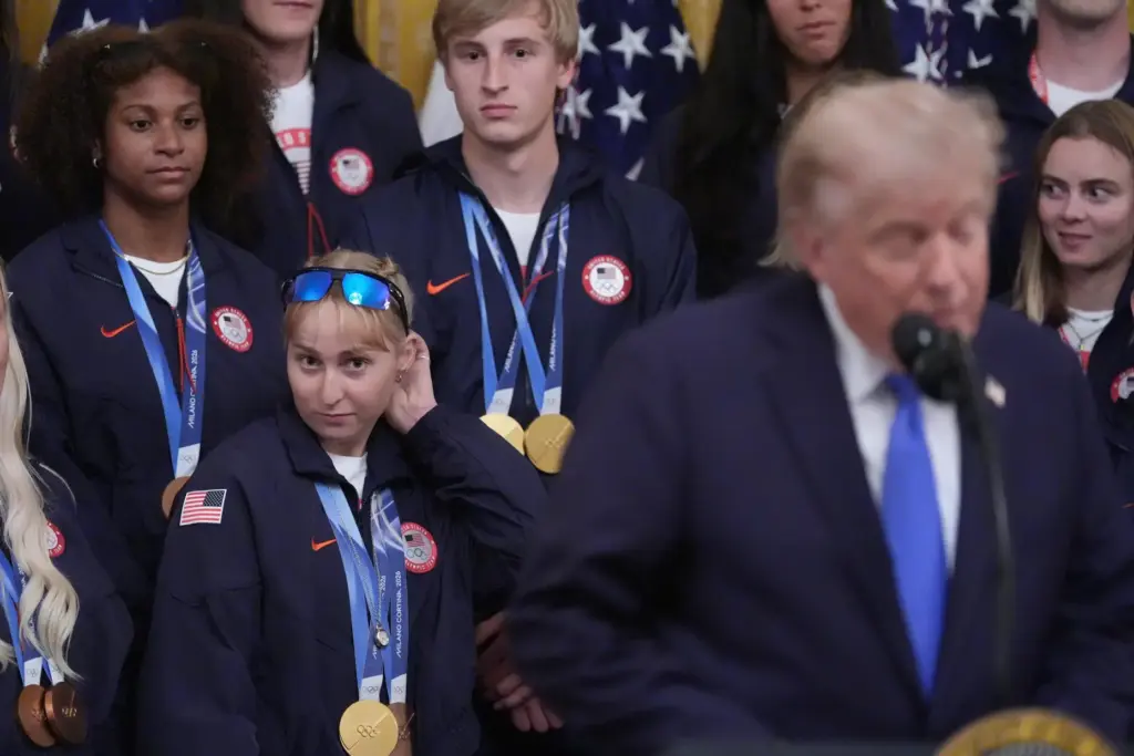 President Donald Trump speaks as Elizabeth Lemley and Jordan Stolz watch.