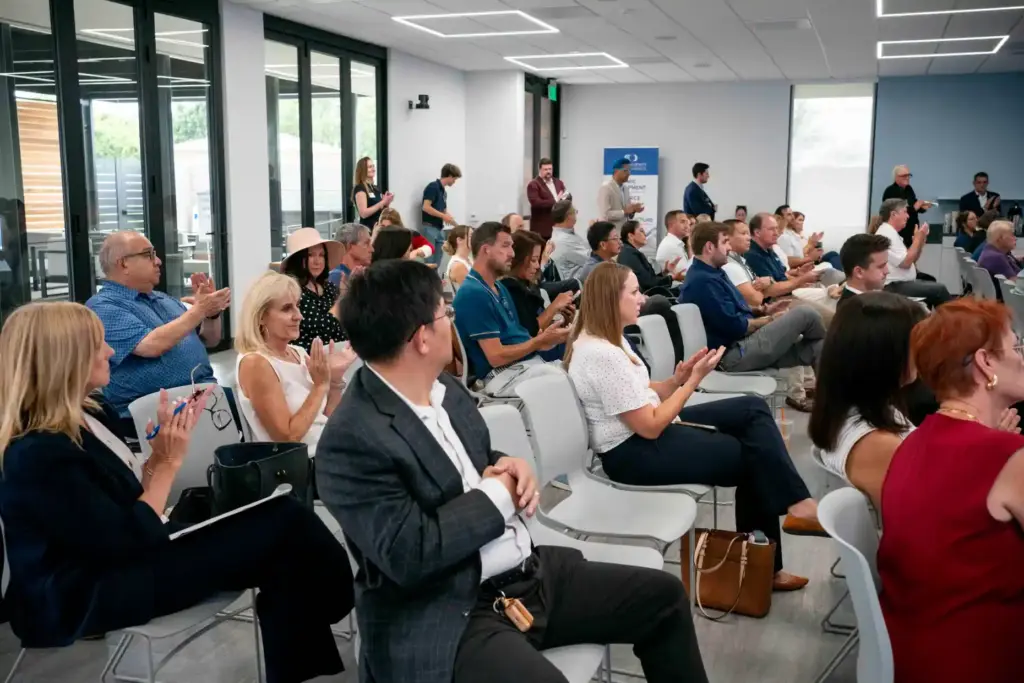 Attendees clap near the beginning of the Orange County Business...