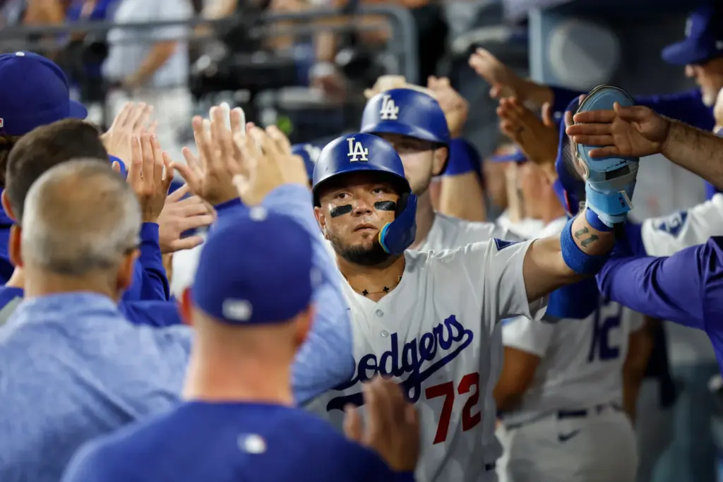 The Dodgers’ Miguel Rojas is greeted by teammates in the...