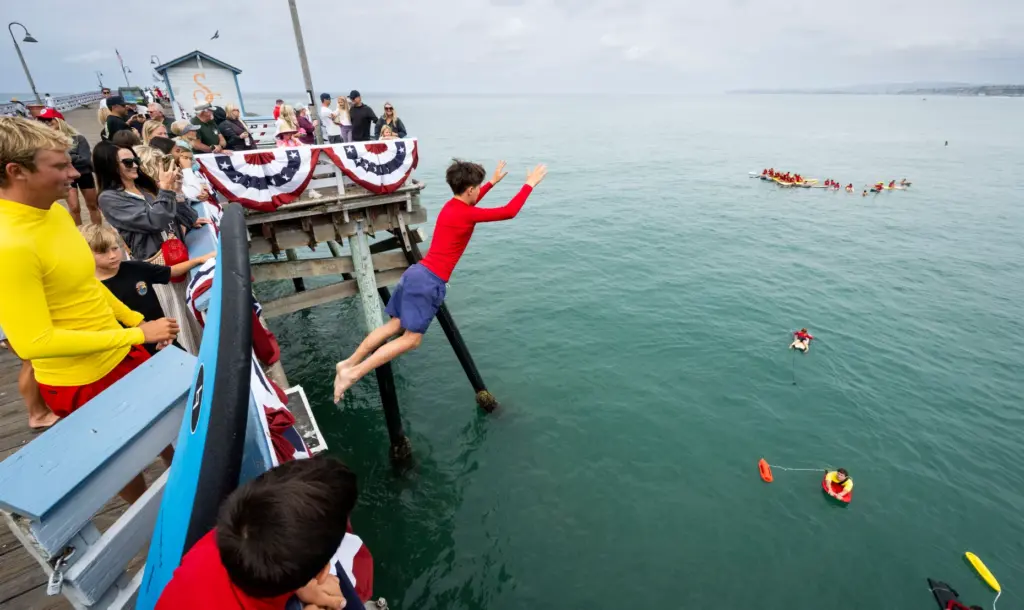 A boy jumps off the San Clemente pier as part...