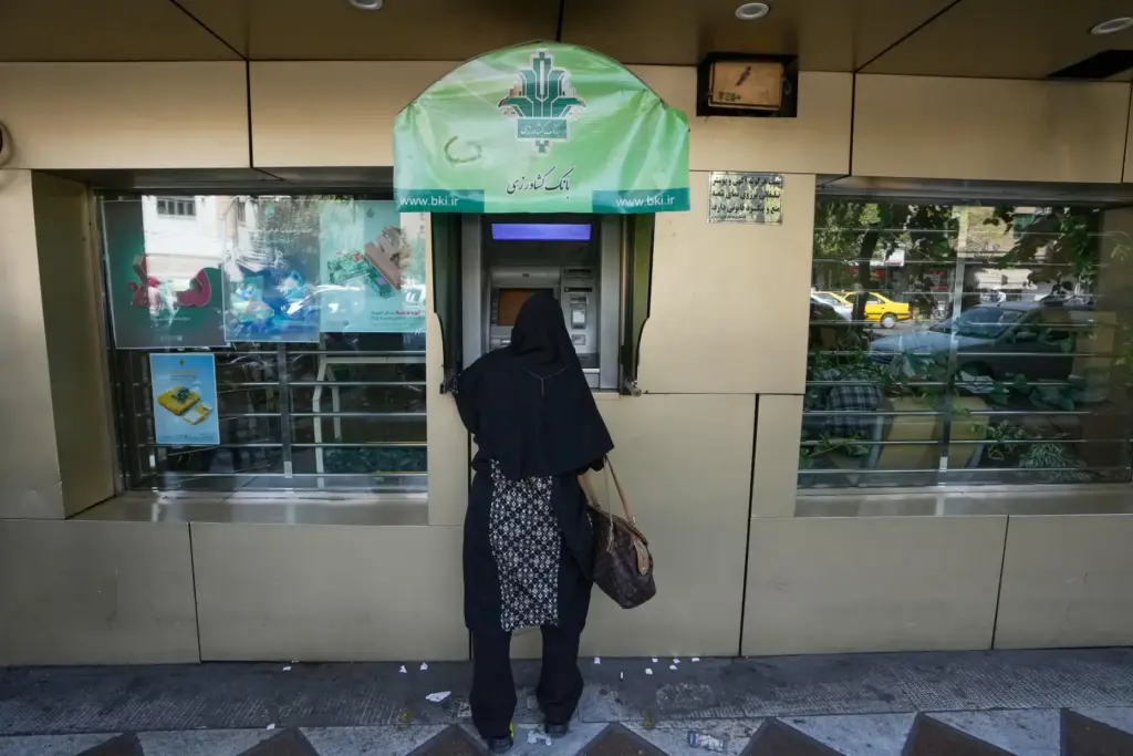 A woman uses an ATM in downtown Tehran, Iran.
