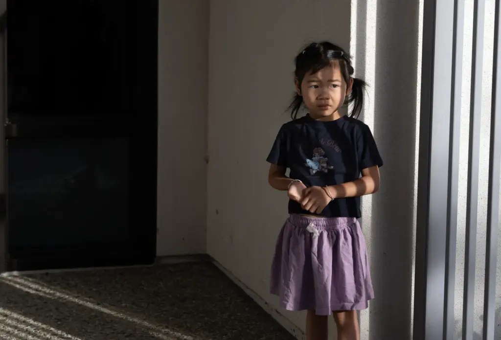 Alia Zhou, 4, appears lost in thought as she waits...