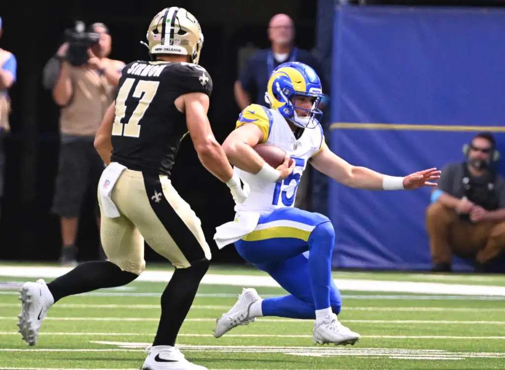 Rams quarterback Ty Simpson (15) slides for yardage past New...