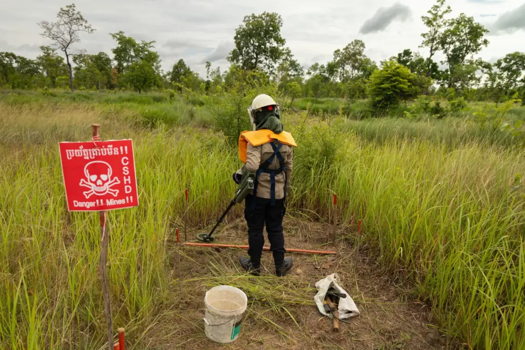 A deminer uses a metal detector to clear a landmine field in Siem Reap, Cambodia.