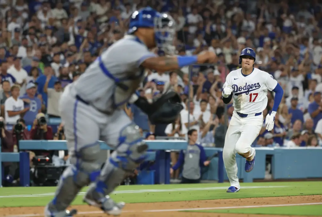 Dodgers star Shohei Ohtani, right, runs home to score the...