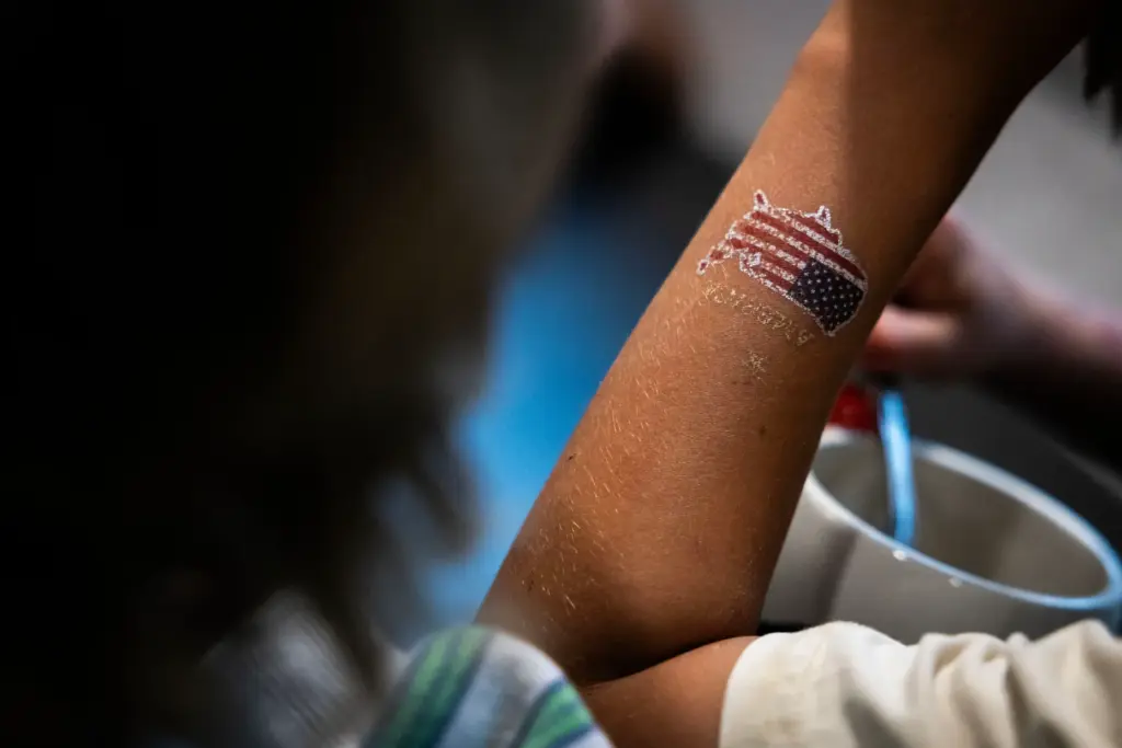 Ellis Campbell, 8, dons a temporary tattoo of the United...
