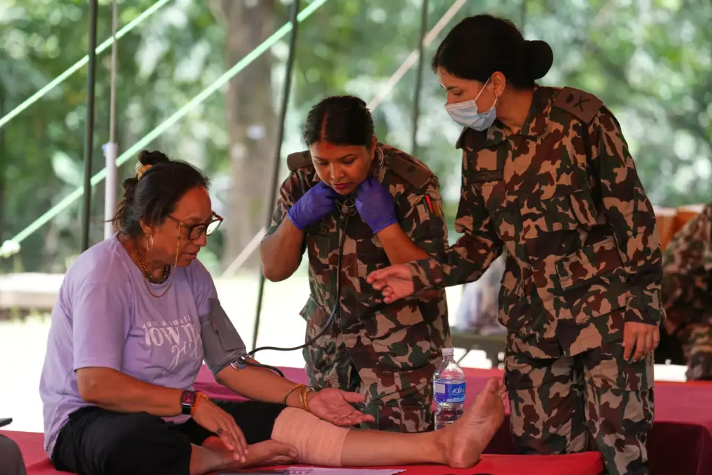 Nepalese army doctors treat a woman rescued from flash flooding.