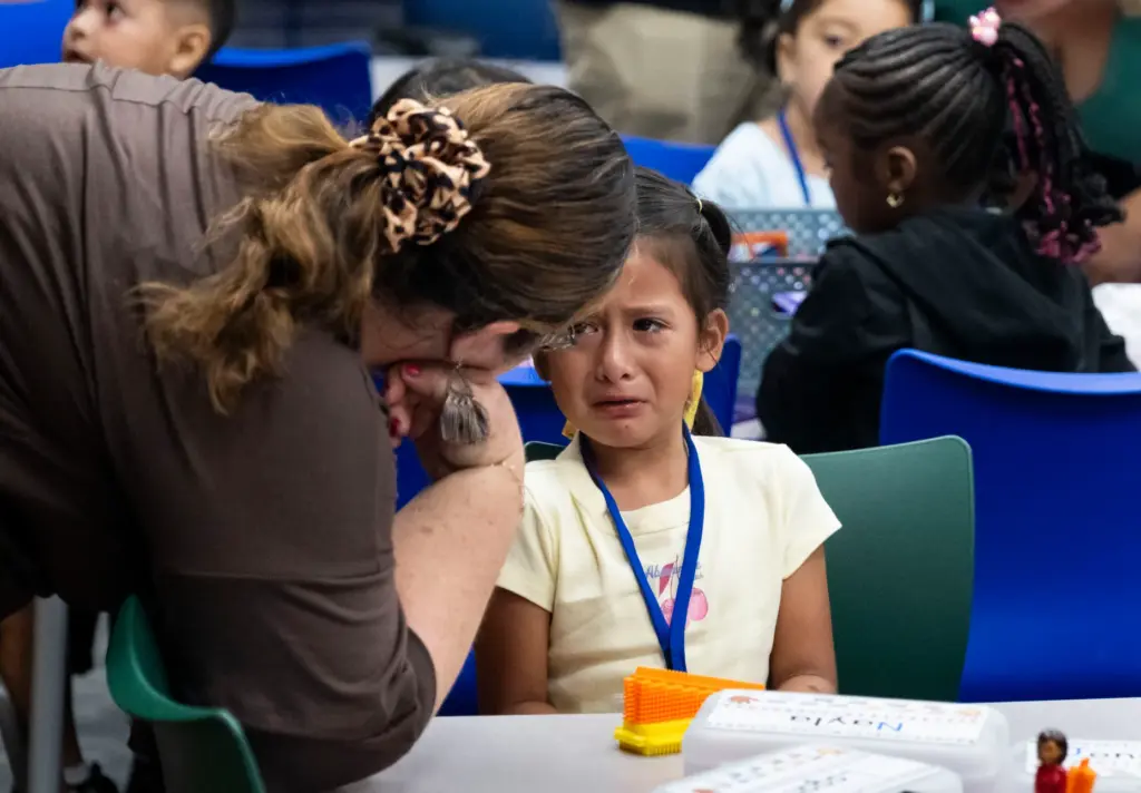Nayla Dubon is consoled by her teacher on the first...