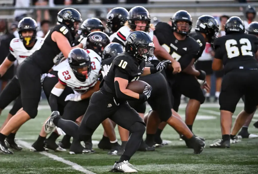 Serviteâs Parker Covin (10) runs with the ball as Centennial...