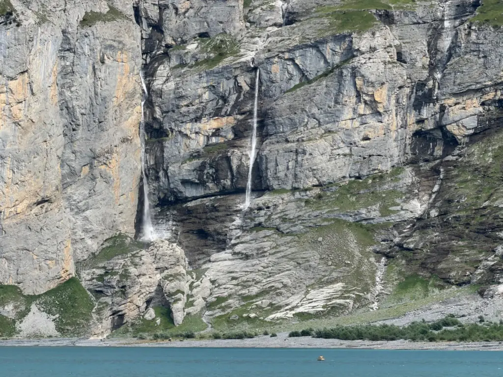 Streams of water from melting glaciers feeding Oeschinensee lake near...