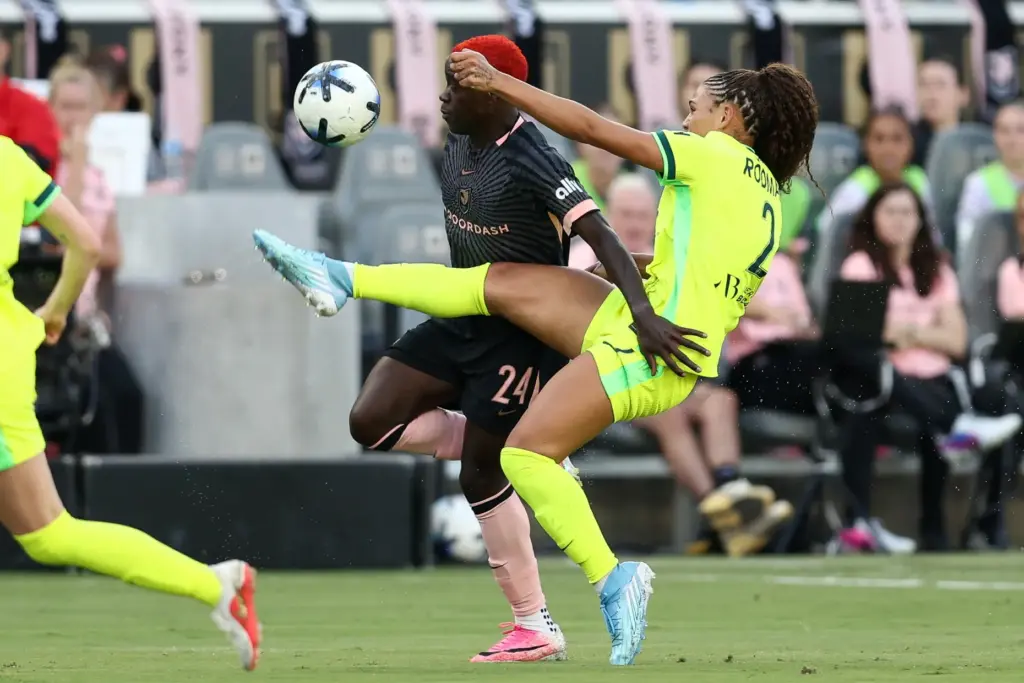Washington Spirit forward Trinity Rodman, front, kicks the ball defended...