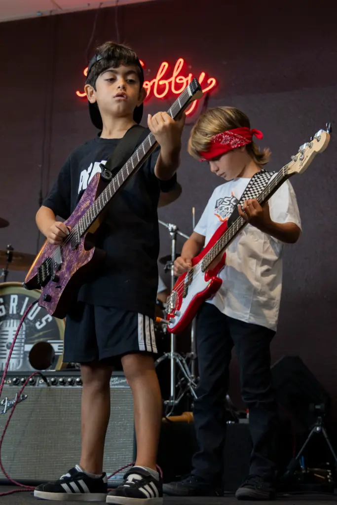 Oliver Almaraz, 8, (left) plays the guitar with Rhett Huffman,...