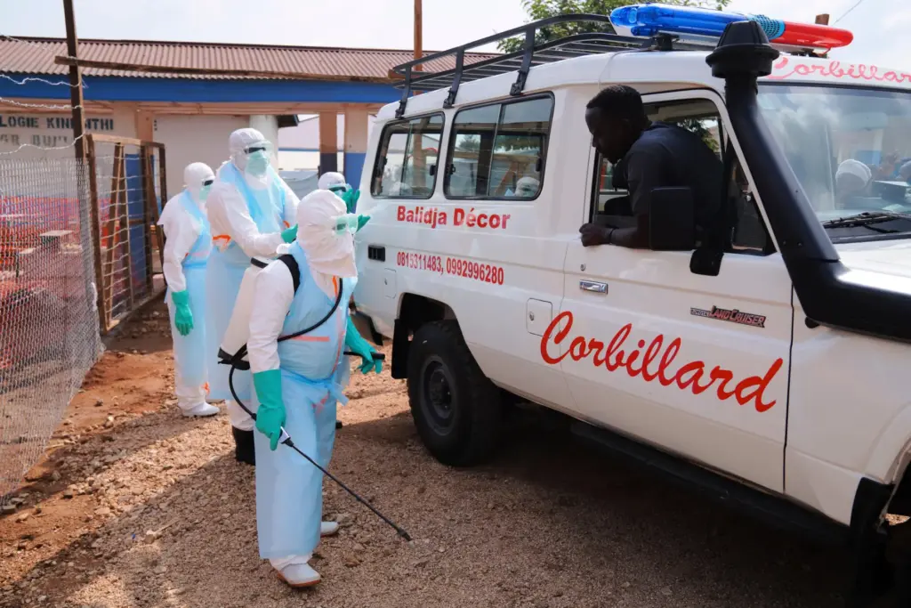 Health workers disinfect an ambulance at Ebola Treatment Center.