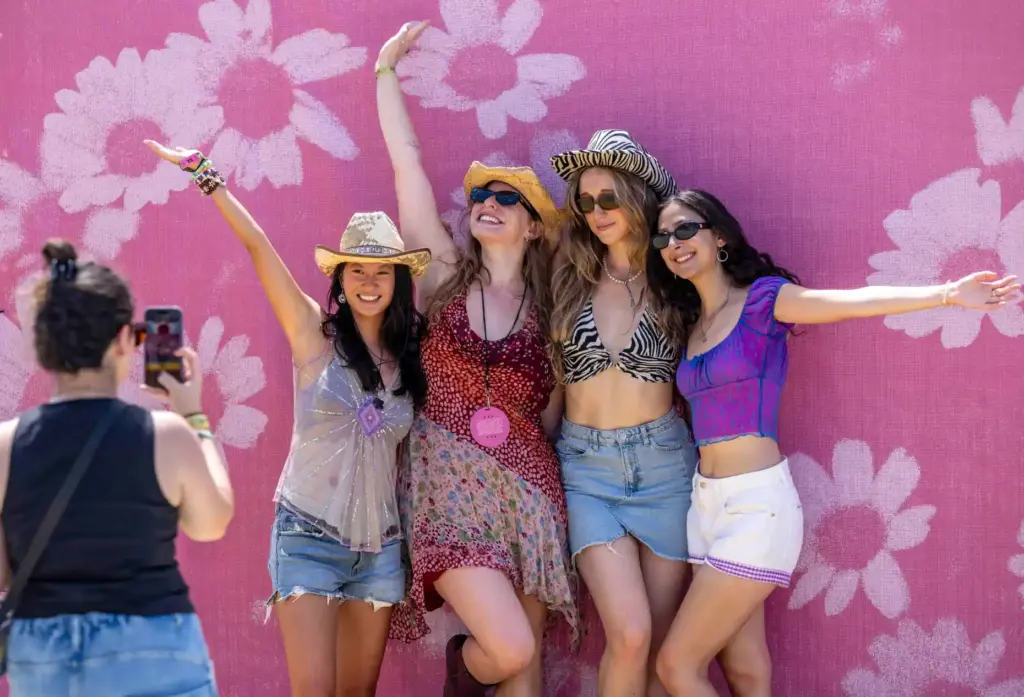 Festivalgoers pose in front of daisies wall at the inaugural...