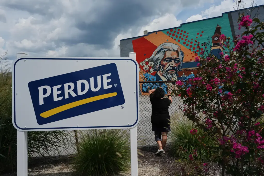 A Honduran woman poses for a portrait outside the Perdue Farms poultry plant.