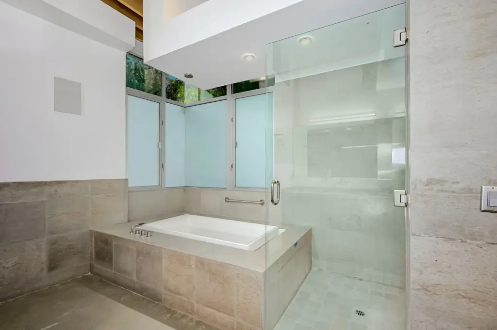 The primary bathroom features a jetted tub and a seamless...