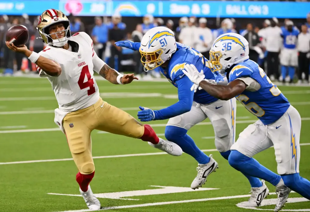 San Francisco 49ers quarterback Adrian Martinez, left, throws a pass...
