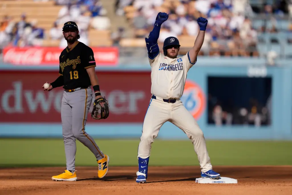 Dodgers’ Max Muncy, right, gestures after hitting a double as...