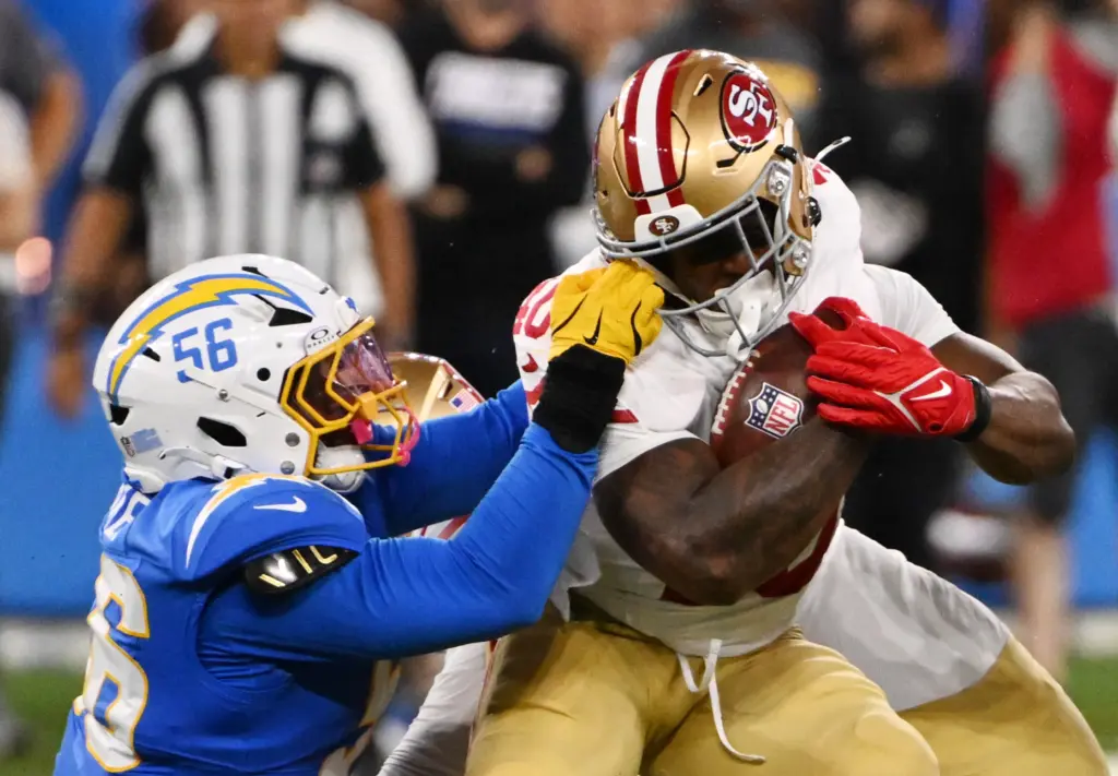 Chargers linebacker Nadame Tucker, left, grabs the facemask of San...