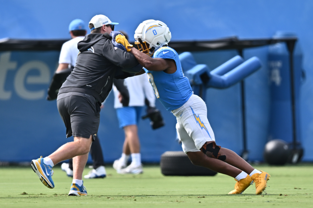 Chargers linebacker Daiyan Henley, right, goes through a blocking drill...