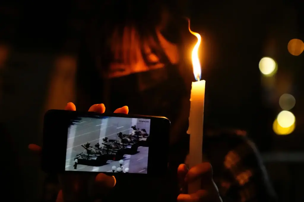 FILE -A woman holds up a candle and an image...