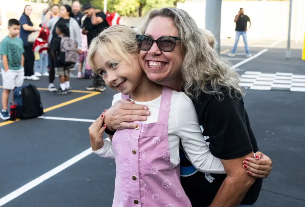 Olivia Coleman gets a hug from her third-grade teacher Michelle...