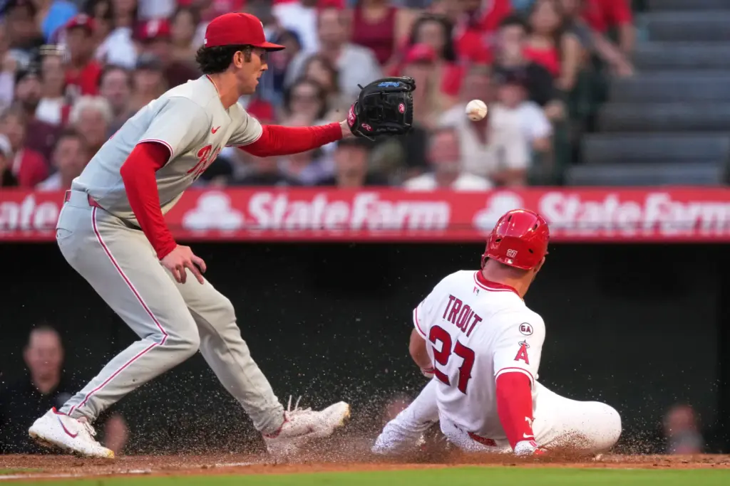 Angels star Mike Trout, right, slides home to score on...