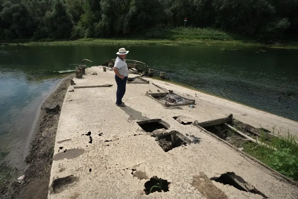Stanislav Kozenko stands on the wreckage of an old steam...