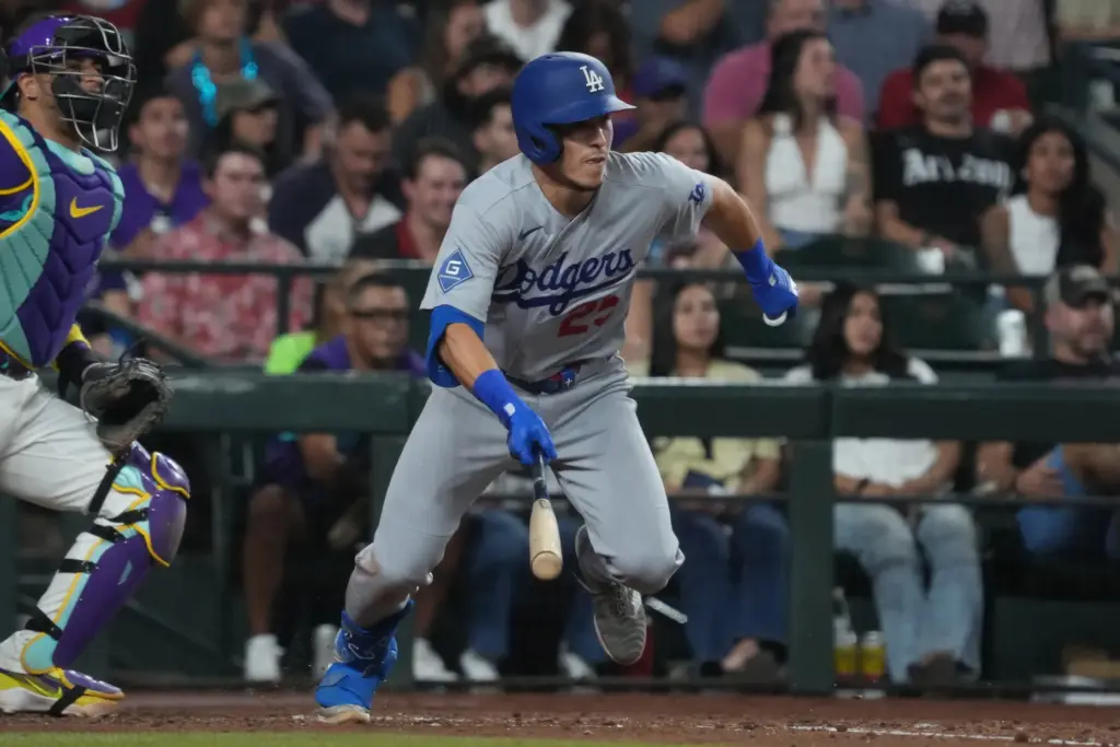 Dodgers second baseman Tommy Edman begins to run after putting...