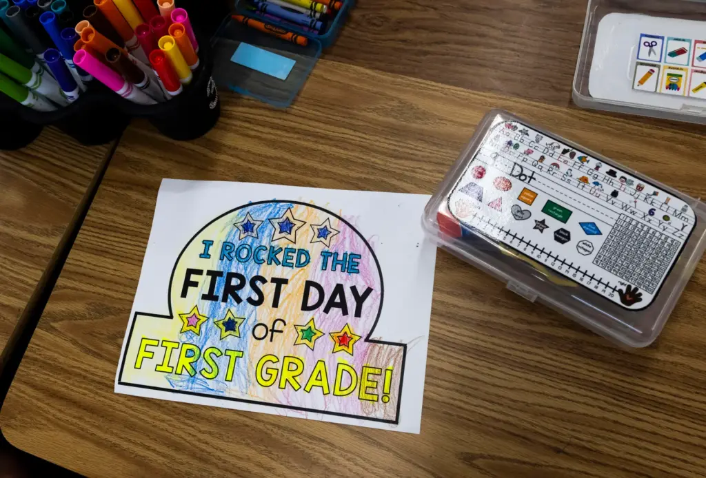 First-grade students work on a coloring project on the first...
