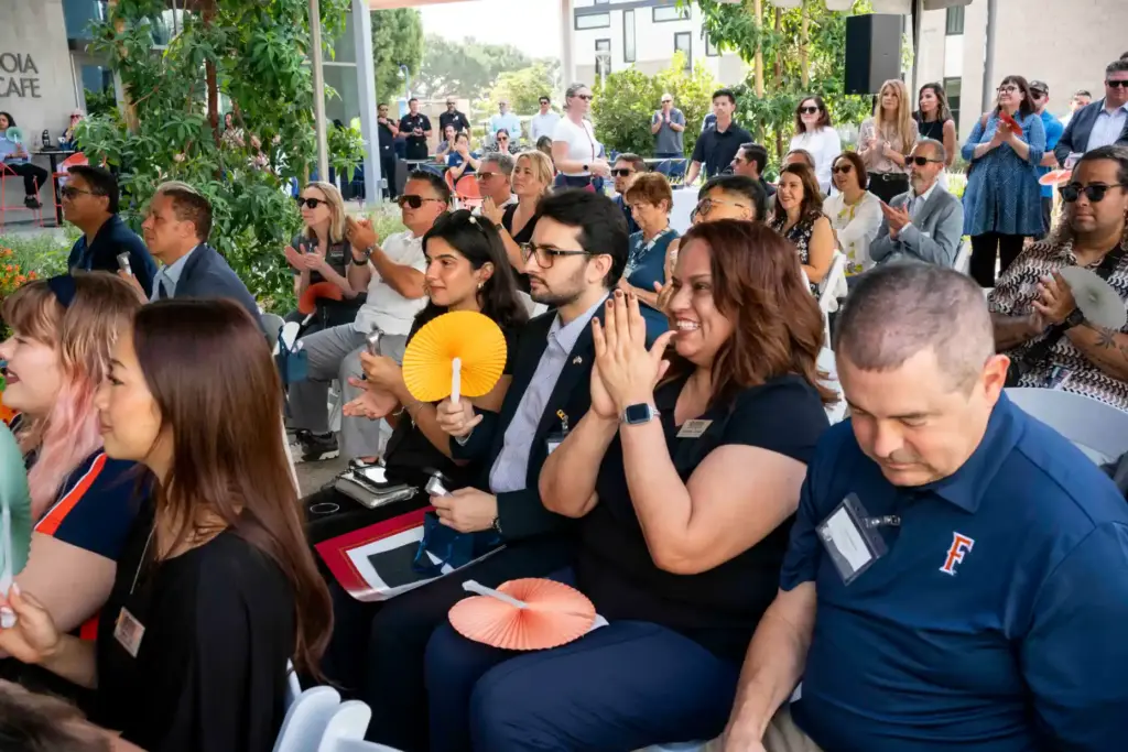 Attendees celebrate following speeches during the grand opening ceremony for...