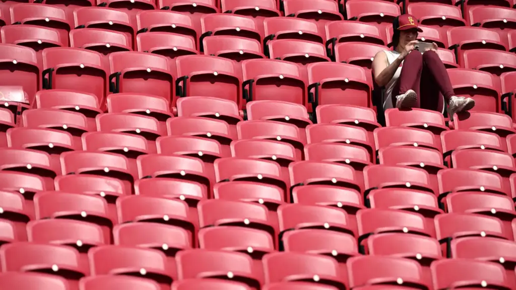 A USC Trojans fan looks on her phone prior to...
