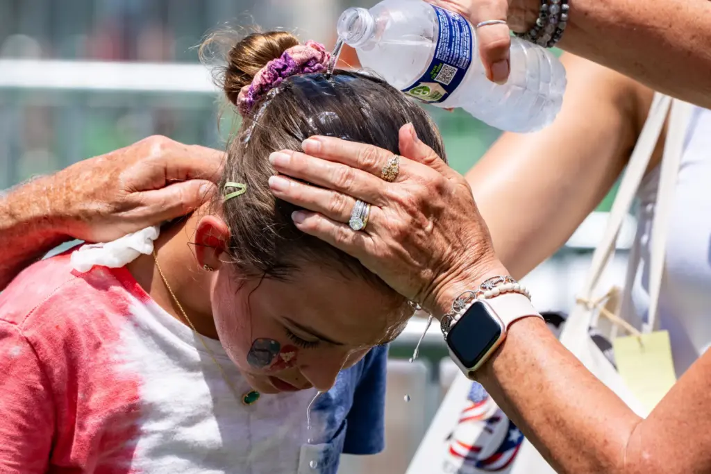 FILE – Ruth, 11, from Burke, Va., gets cold water...