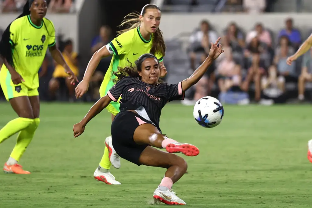 Angel City FC midfielder Taylor Suarez, bottom, kicks the ball...