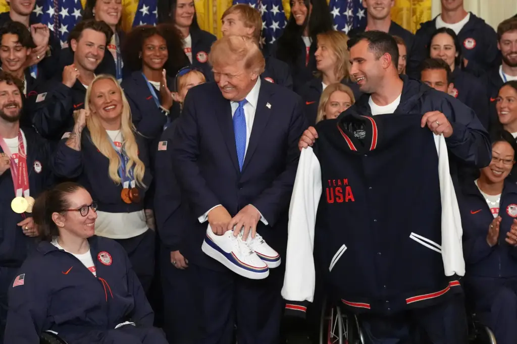 President Donald Trump poses with alpine monoskier Laurie Stephens and bobsledder Frank Del Duca.