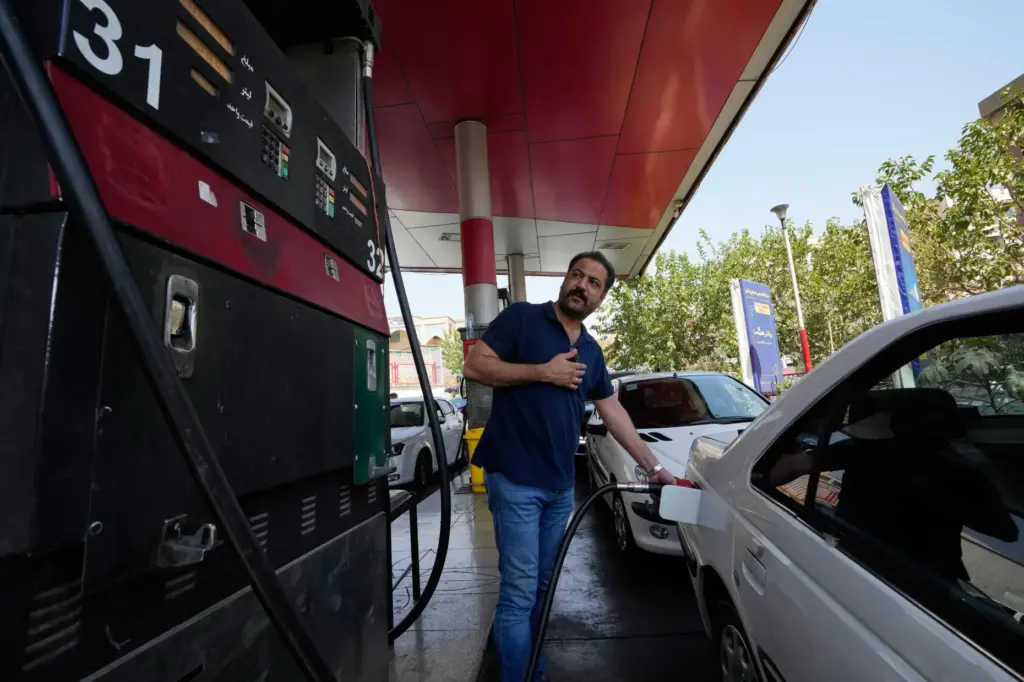 A man is filling up his car at a gas...