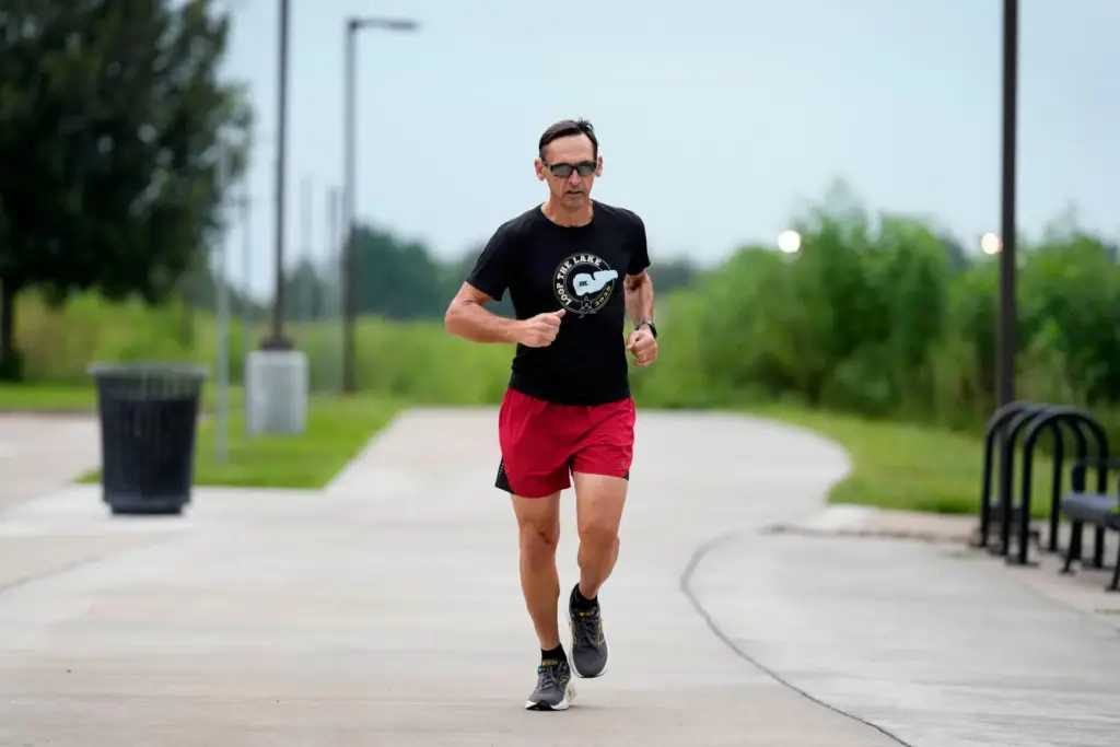 Paul Grinvalds warms up before running with the Raccoon River Running Club.