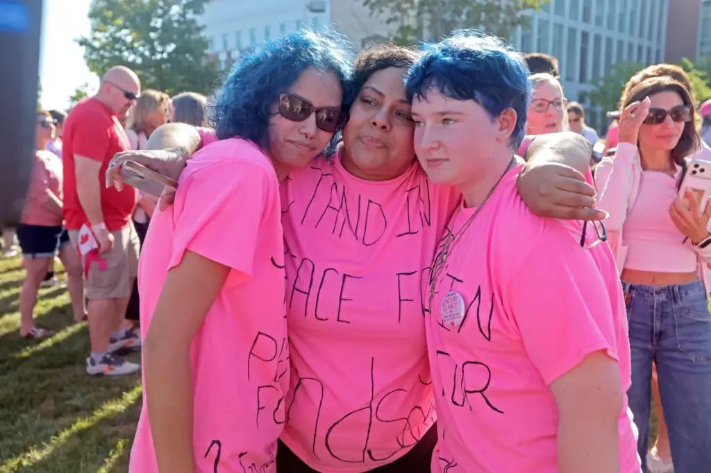 Jasyiah Rivera, Jennifer Alie and Katelynn Welch hold each other.