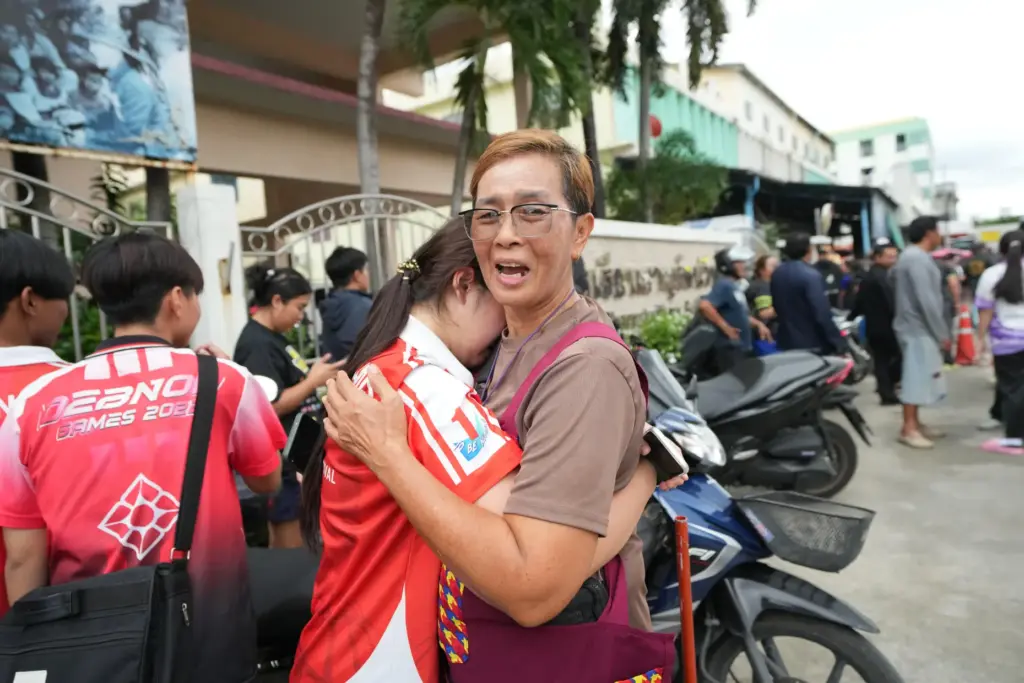 A schoolgirl cries outside her school.