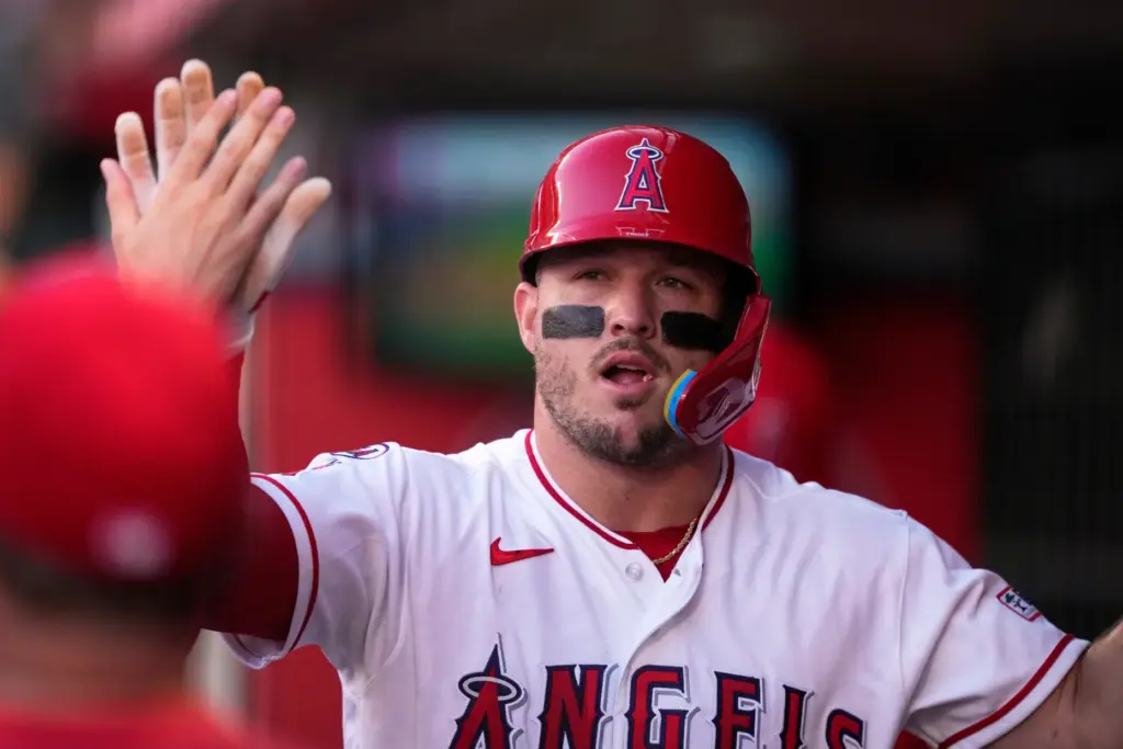 Angels star Mike Trout is congratulated in the dugout after...