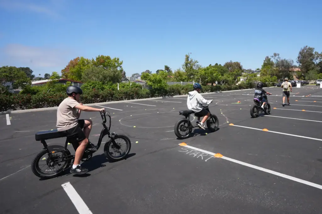 A group of kids ride e-bikes during an e-bike safety...