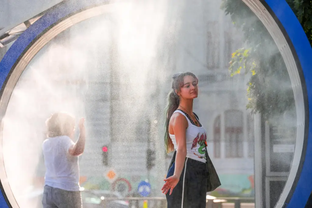 FILE – A woman pauses while she walks through a...